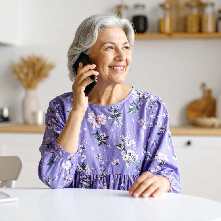 Women talking on the phone in her kitchen