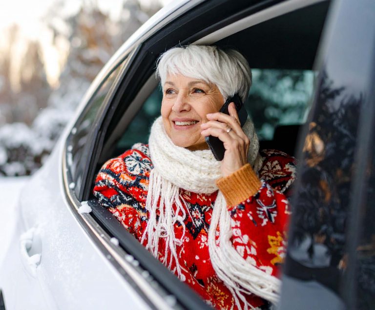 Senior woman riding in an Uber and talking on her cell phone
