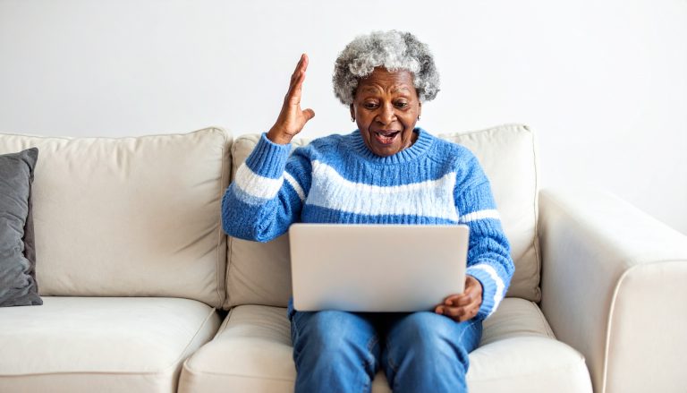 Senior female reading her email while sitting on her couch.