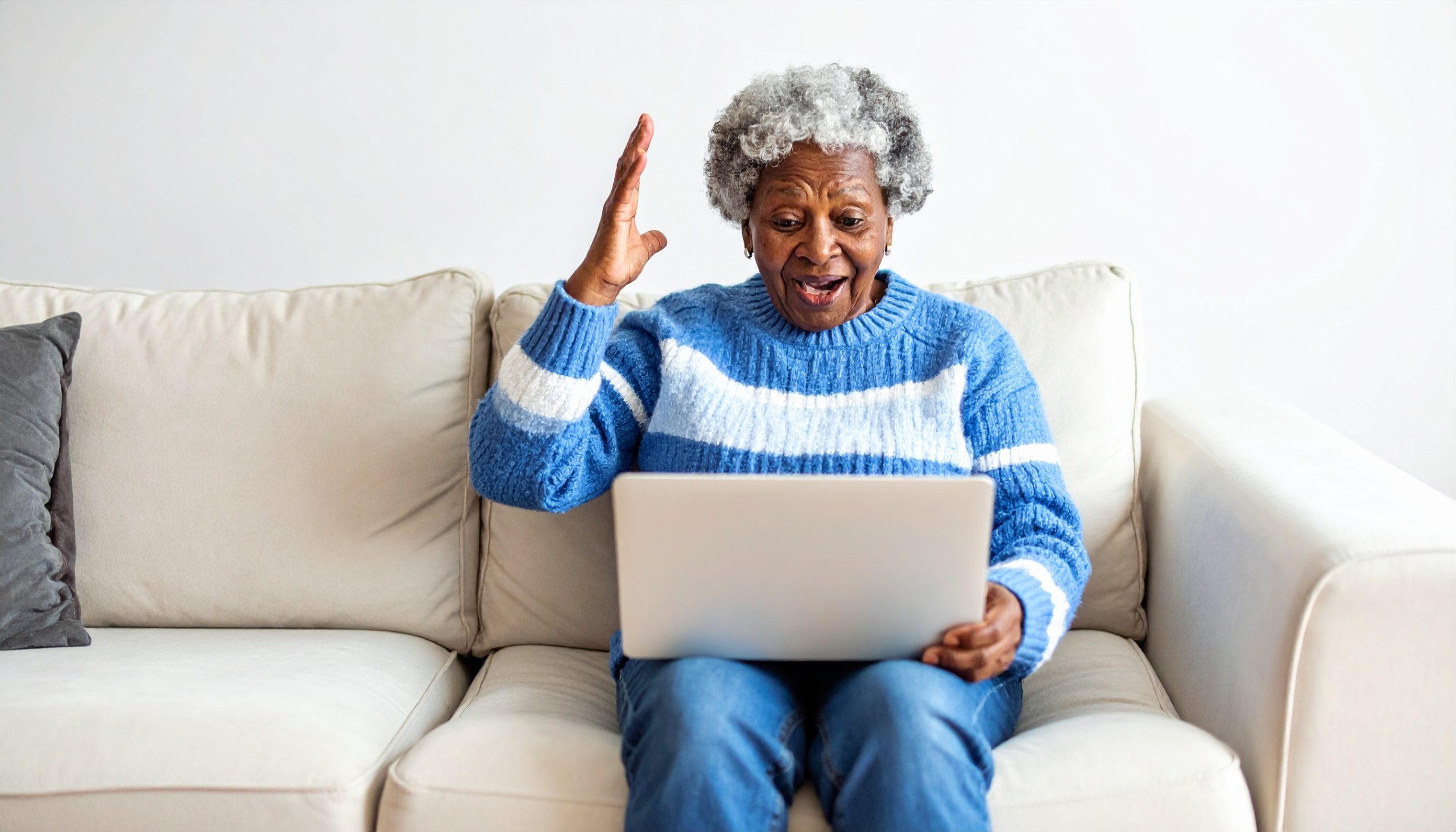 Senior female reading her email while sitting on her couch.